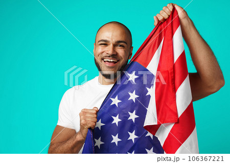 Portrait of young dark-skinned man proudly holding USA flag 106367221
