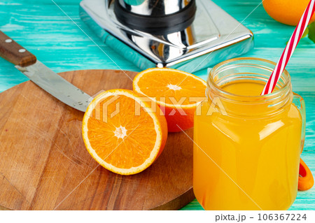 Glass with orange juice on green wooden table Glass with orange juice on green wooden table 106367224