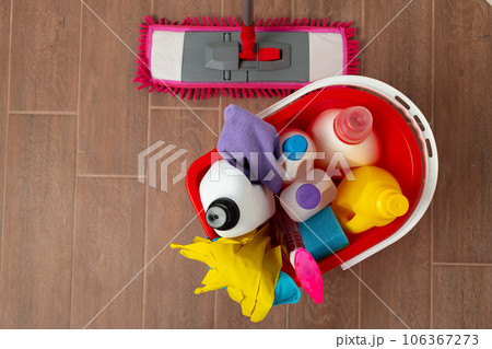 Various household cleaning detergents and bottles in a plastic bucket on the floor Various household cleaning detergents and bottles in a plastic bucket on the floor 106367273
