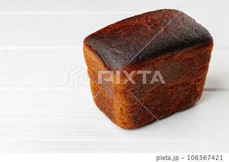 Loaf of rye bread on white wooden table 106367421