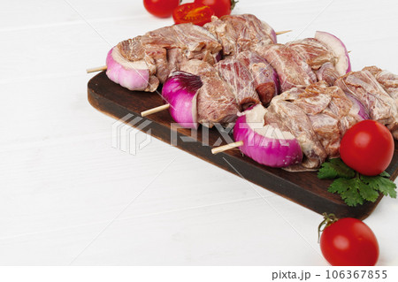 Raw marinated kebab on skewers on wooden background Raw marinated kebab on skewers on wooden background 106367855
