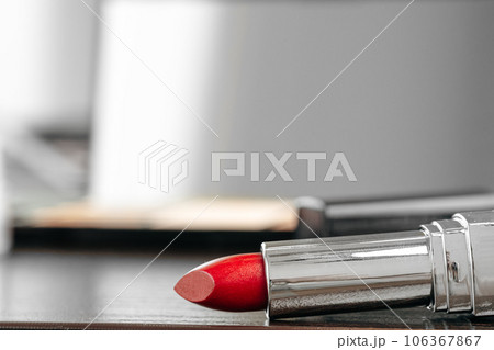 New red lipstick on vanity table close up New red lipstick on vanity table close up 106367867