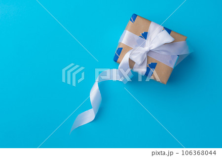 Top view of gift box with ribbon on blue background Top view of gift box with ribbon on blue background 106368044