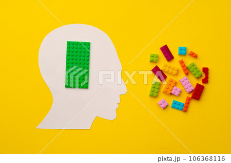 Papercut head silhouette with toy constructor pieces on yellow background 106368116