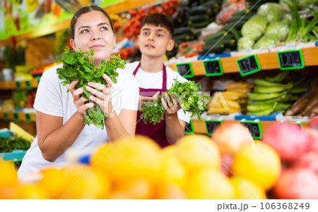 Supermarket salesman helps girl to choose mint Supermarket salesman helps girl to choose mint 106368249