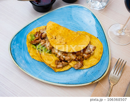 Mexican tacos with chicken, guacamole and sauces 106368507