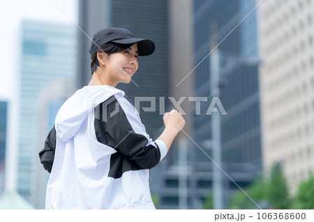 都会でジョギング前にストレッチをする若い女性 106368600