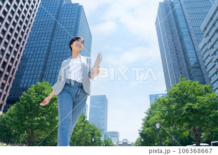 オフィス街で働くオフィスカジュアルの若いビジネスウーマン オフィス街で働くオフィスカジュアルの若いビジネスウーマン 106368667