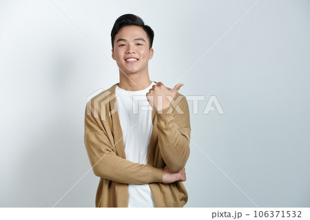 Attractive cheerful young man standing isolated over white background, showing thumbs up Attractive cheerful young man standing isolated over white background, showing thumbs up 106371532