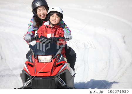 スノーモービルに乗る親子 106371989