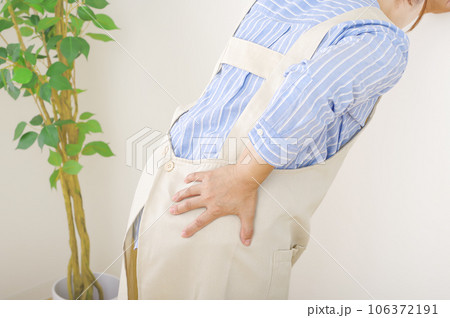 腰が痛そうなエプロン姿の女性 106372191