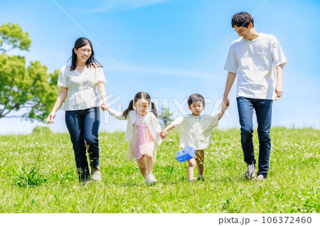 青空の草原を散歩する家族 106372460