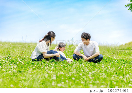 青空の草原に座って泣く息子と家族 青空の草原に座って泣く息子と家族 106372462