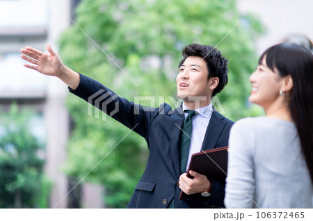現地案内する不動産業者の男性と女性客 106372465