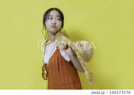 黄色背景の若い女性のポートレート 106373576