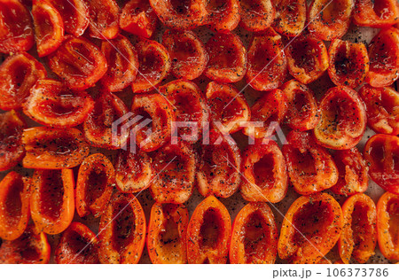 Sun-dried tomatoes on a baking tray. Fresh tomatoes sprinkled with aromatic seasonings. High quality photo Sun-dried tomatoes on a baking tray. Fresh tomatoes sprinkled with aromatic seasonings. High quality photo 106373786