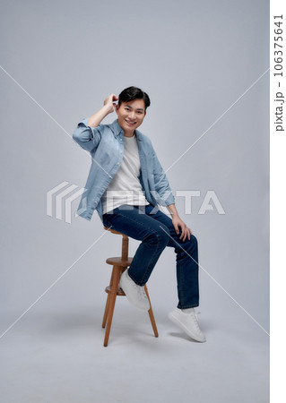 Young Asian man sitting on white background Young Asian man sitting on white background 106375641