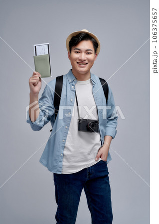 Smiling young man student in backpack hold books passport boarding pass tickets 106375657