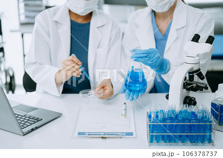 Scientist team meeting and writing analysis results in the laboratory study and analyze scientific sample. 106378737