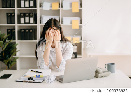 Asian business woman is stressed, bored, and overthinking from working on a tablet at the modern office. Asian business woman is stressed, bored, and overthinking from working on a tablet at the modern office. 106378925