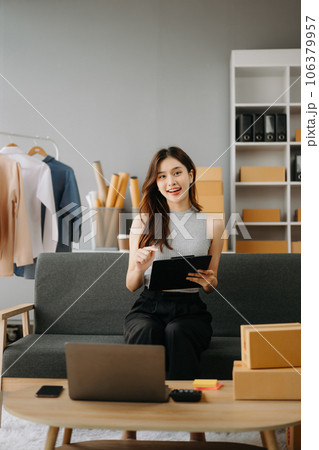 Fashion blogger concept, Young Asian women selling clothes on video streaming.Startup small business SME, using smartphone or tablet taking receive and checking. 106379957