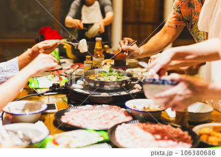 Group of friends cooking the Chinese shabu hotpot at home. Group of friends cooking the Chinese shabu hotpot at home. 106380686