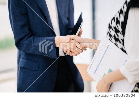 Two confident business man shaking hands during a meeting in the office, success, dealing, greeting and partner in sun light Two confident business man shaking hands during a meeting in the office, success, dealing, greeting and partner in sun light 106380804