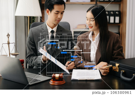 Business and lawyers discussing contract papers with brass scale on desk in office. Law, legal services, advice, justice and law concept .. Business and lawyers discussing contract papers with brass scale on desk in office. Law, legal services, advice, justice and law concept .. 106380961