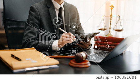 justice and law concept.Male judge in a courtroom the gavel, working with smart phone and laptop and digital tablet computer on wood table justice and law concept.Male judge in a courtroom the gavel, working with smart phone and laptop and digital tablet computer on wood table 106381081