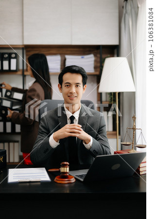 Asian lawyer man working with a laptop and tablet in a law office. Legal and legal service concept. Looking at camera in modern office. Asian lawyer man working with a laptop and tablet in a law office. Legal and legal service concept. Looking at camera in modern office. 106381084