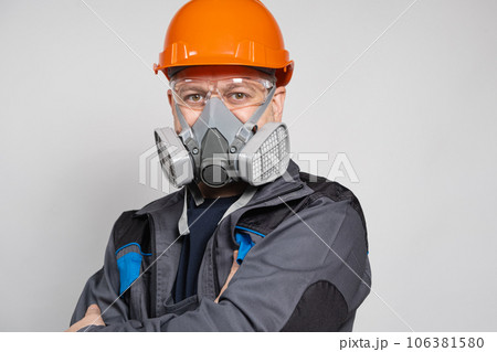 A man wearing a helmet, respirator and goggles on a white background 106381580