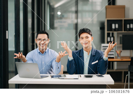 Two Asian business workers talking on the smartphone, tablet and using laptop at the office. 106381676