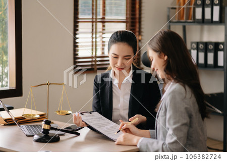 Judge gavel with scales of justice, Business and lawyer or counselor consulting and discussing contract papers with laptop and tablet at law firm in office. 106382724