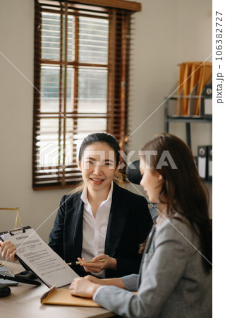 Judge gavel with scales of justice, Business and lawyer or counselor consulting and discussing contract papers with laptop and tablet at law firm in office. 106382727