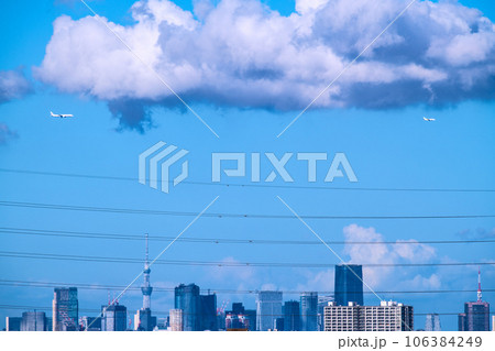 日本の東京都市景観 2機の航空機。列をなし都心上空を通過する航空機。脱コロナ、航空需要回復＝8月 106384249