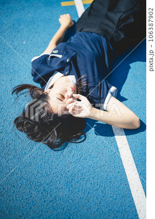 真夏の陸上競技場とポロシャツの若い女性 106387902