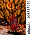 Preparation of mulled wine from wine. Splashes of wine, falling glass, spices 106387962
