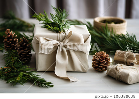 Stylish christmas gift wrapped in fabric on rustic table with