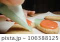 I color the gingerbread cookie with green icing from a small pastry bag. 106388125