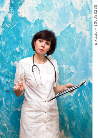 Woman doctor with documents on blue background Woman doctor with documents on blue background 106388288