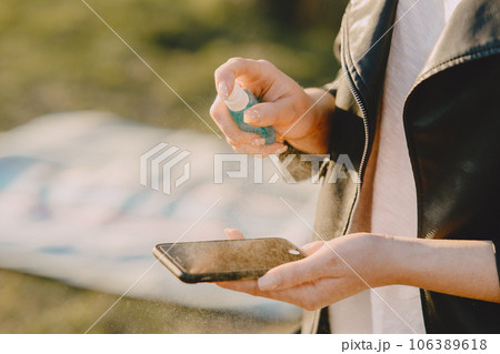 Woman with phone. Person use antiseptick. Corona virus theme. 106389618