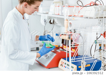 Female researcher using machine for experiment Female researcher using machine for experiment 106392312