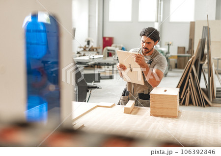 Young man doing woodwork in carpentry factory Young man doing woodwork in carpentry factory 106392846