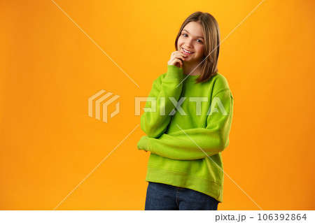 Photo of teen girl smiling portrait against yellow background in studio 106392864