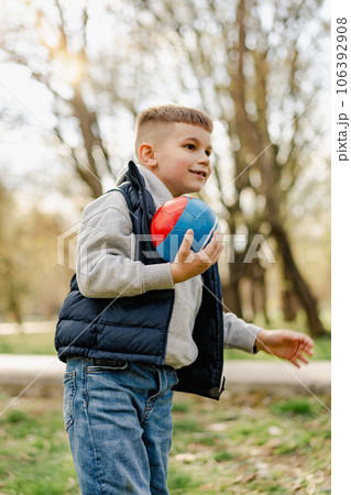 Little boy playing with a ball in the park 106392908