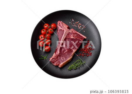 Raw juicy beef t-bone steak with salt, spices and herbs Raw juicy beef t-bone steak with salt, spices and herbs 106393815