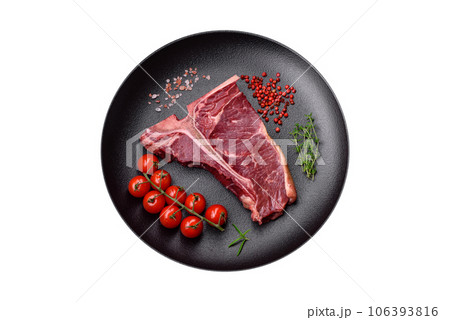 Raw juicy beef t-bone steak with salt, spices and herbs Raw juicy beef t-bone steak with salt, spices and herbs 106393816