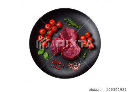 Juicy raw beef with spices, salt and herbs on a dark concrete background Juicy raw beef with spices, salt and herbs on a dark concrete background 106393981