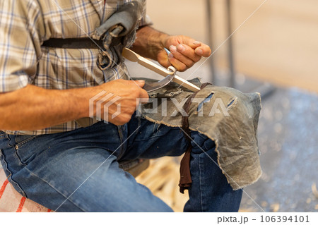 A man planing a wooden figurine using a sickle A man planing a wooden figurine using a sickle 106394101