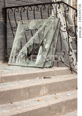 Missile attack in Kyiv, Ukraine, august 2023. Broken windows and shuttered glass on stairs after explosion. House damaged by blast wave. War in Ukraine. Russian aggression against civil people. 106394736